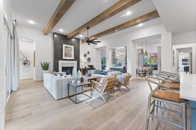 Living room in new build by Sitterle Homes featuring wood beam ceiling and natural light