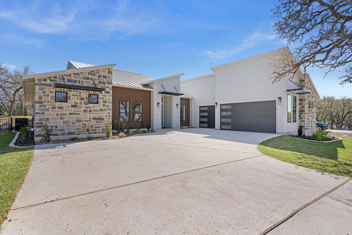 Front exterior of a custom home in the Belle Oaks acreage homesites community featuring stone accents and Hill Country design.